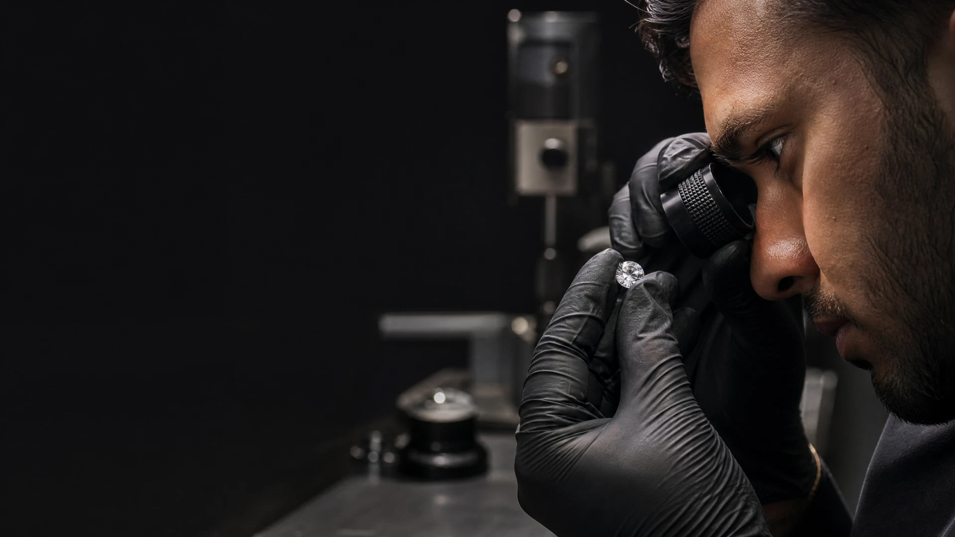 A diamond being inspected through a jeweller's loupe during quality control.